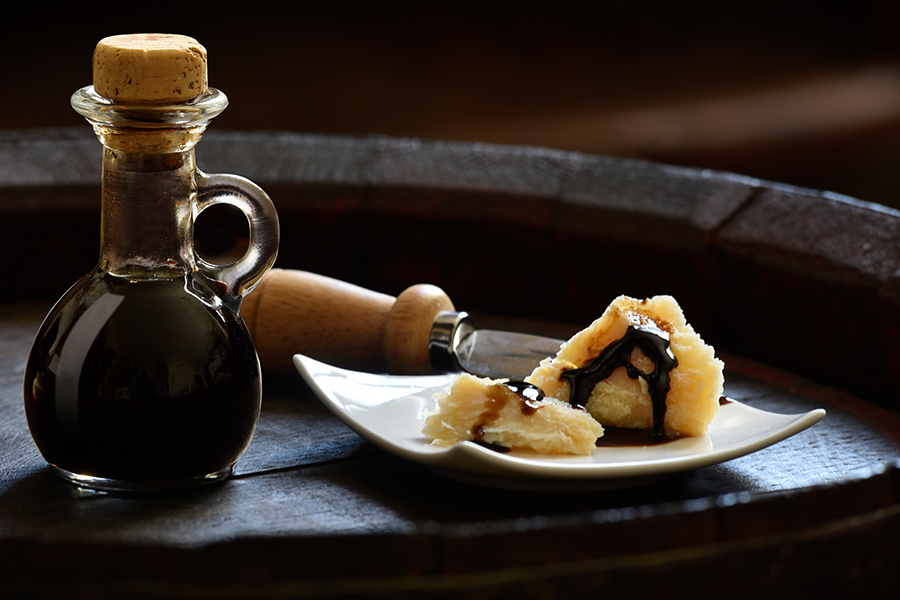 balsamic-vinegar-900x600.jpg Balsamic Vinegar of Modena with Parmesan flakes set on plates and a wooden barrel